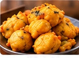 Golden fried aloo chop savory fritters piled on a silver plate
