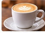 Cappuccino with rosetta latte art in a white ceramic cup