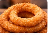 Golden-brown crispy fried sel roti rings stacked together